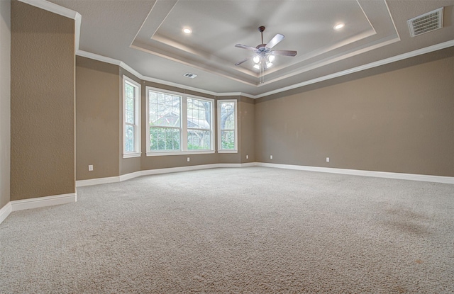 unfurnished room featuring ceiling fan, ornamental molding, a tray ceiling, and carpet