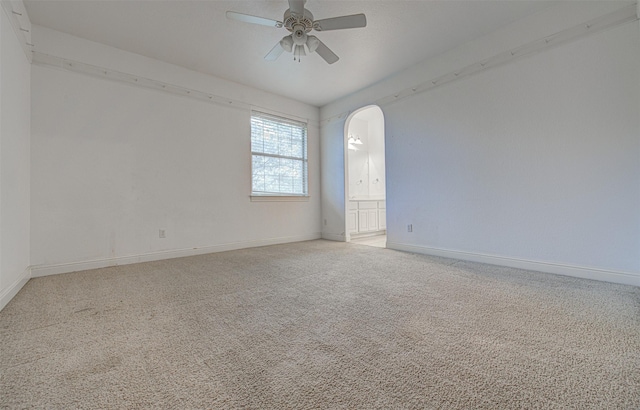 carpeted spare room featuring ceiling fan