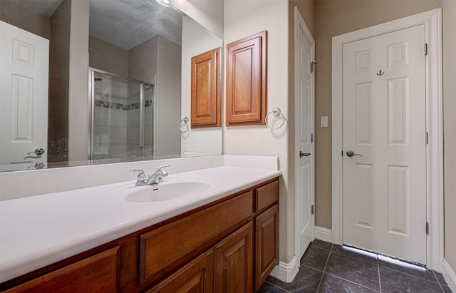 bathroom featuring tile patterned floors, vanity, and a shower with shower door