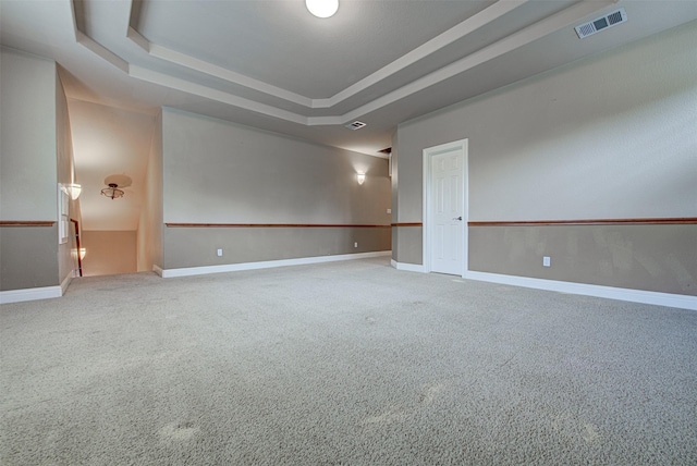 carpeted spare room with a tray ceiling