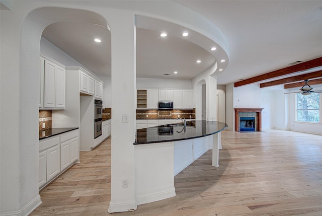 kitchen with decorative backsplash, white cabinets, and appliances with stainless steel finishes