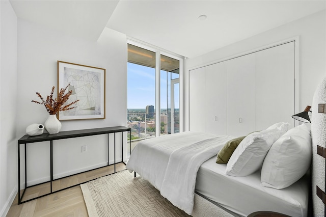 bedroom with light parquet floors and floor to ceiling windows