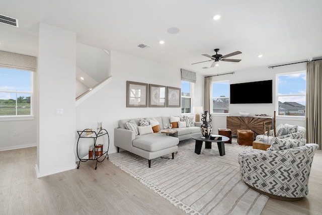 living room featuring ceiling fan, light hardwood / wood-style floors, and a wealth of natural light