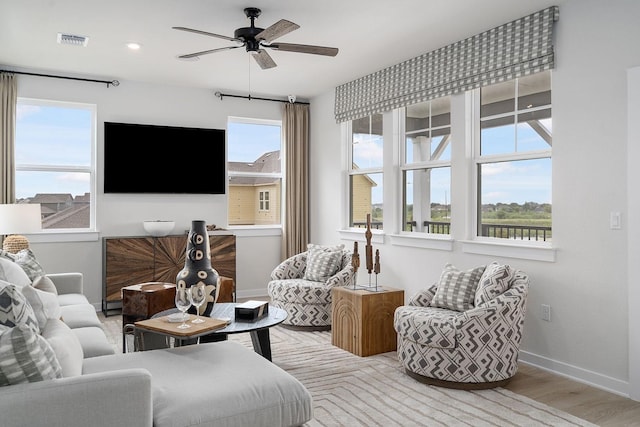 living room featuring ceiling fan, light hardwood / wood-style flooring, and a healthy amount of sunlight