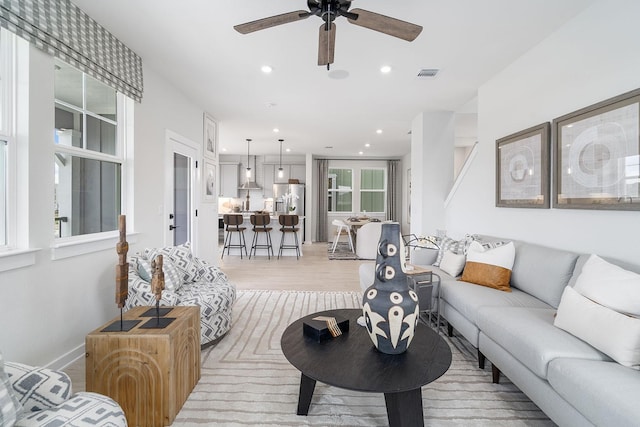 living room with ceiling fan and light hardwood / wood-style floors