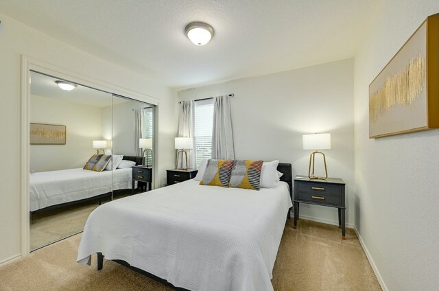 bedroom featuring a closet, carpet flooring, and baseboards