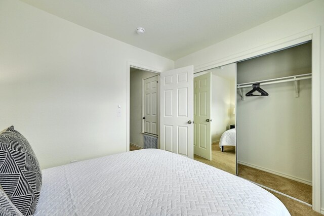 bedroom featuring carpet flooring, baseboards, and a closet