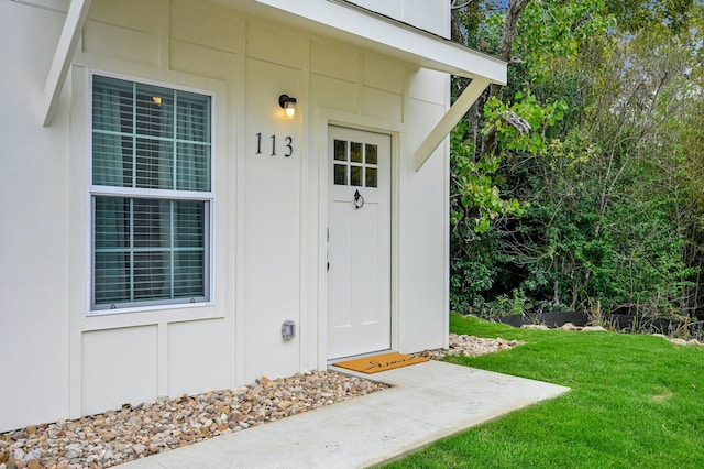 view of exterior entry with a lawn