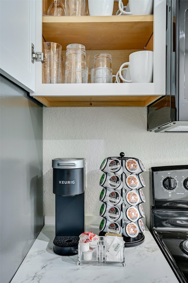 details with black electric range and white cabinets