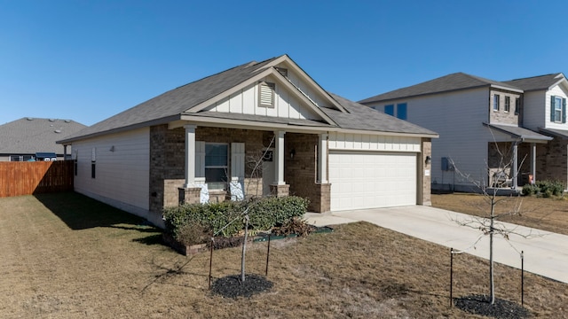 view of front of house with a garage, covered porch, and a front lawn