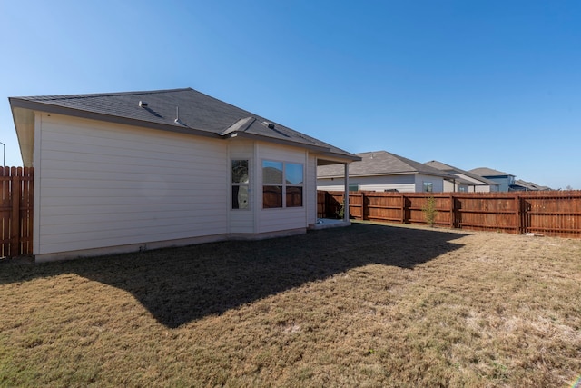 rear view of house featuring a lawn