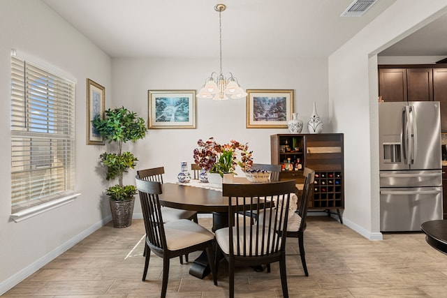 dining room featuring a notable chandelier and light hardwood / wood-style floors