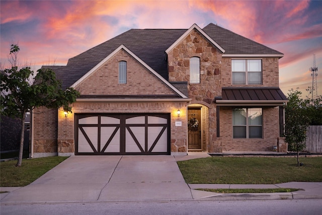 view of front of home featuring a garage and a lawn