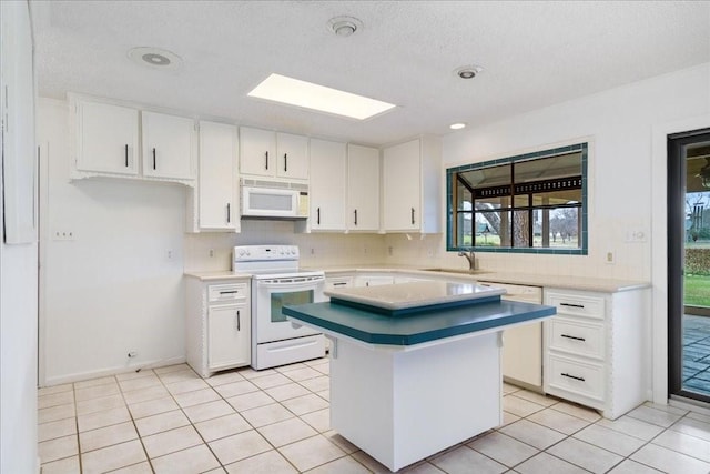 kitchen with white cabinetry, a center island, sink, and white appliances