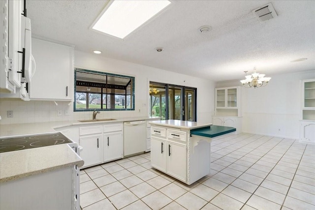 kitchen with sink, decorative light fixtures, a kitchen island, white appliances, and white cabinets