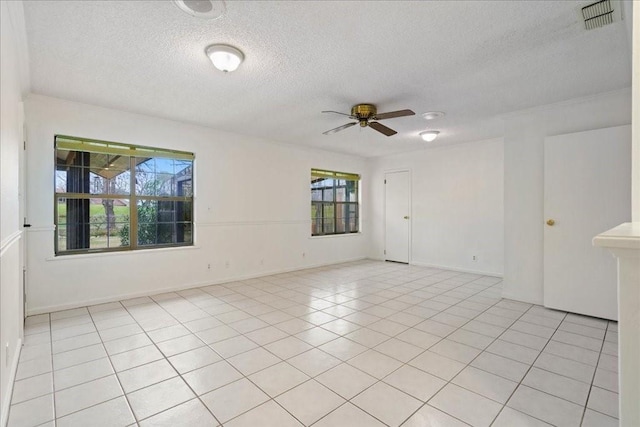 tiled spare room with ceiling fan and a textured ceiling