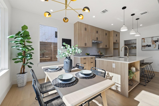 dining area featuring sink and light wood-type flooring