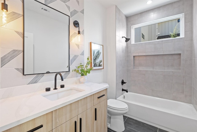 full bathroom featuring tiled shower / bath, vanity, tile patterned floors, and toilet