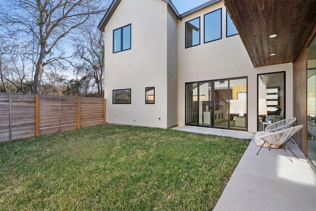 back of property with a yard and a patio area