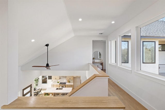 interior space with light hardwood / wood-style floors and vaulted ceiling