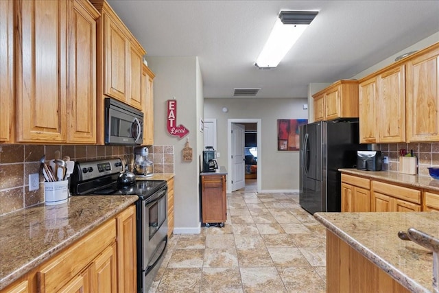 kitchen featuring stainless steel appliances, tasteful backsplash, and light stone countertops