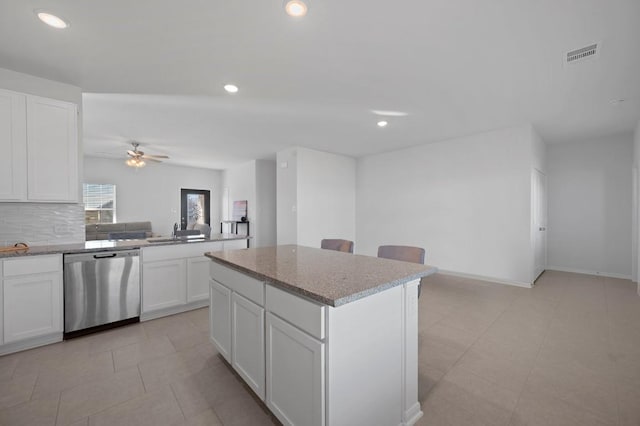 305 Ravens Crest Dr, Hutto, TX 78634 - kitchen featuring stainless steel dishwasher, a sink, ceiling fan, a center island, and white cabinetry