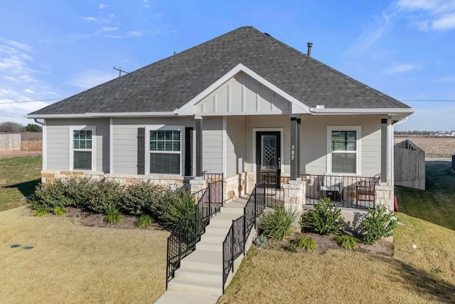 305 Ravens Crest Dr, Hutto, TX 78634 - bungalow-style home with roof with shingles, stone siding, board and batten siding, covered porch, and a front yard