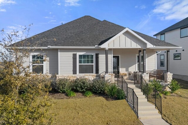 305 Ravens Crest Dr, Hutto, TX 78634 - view of front of property featuring a porch, board and batten siding, a shingled roof, and a front yard