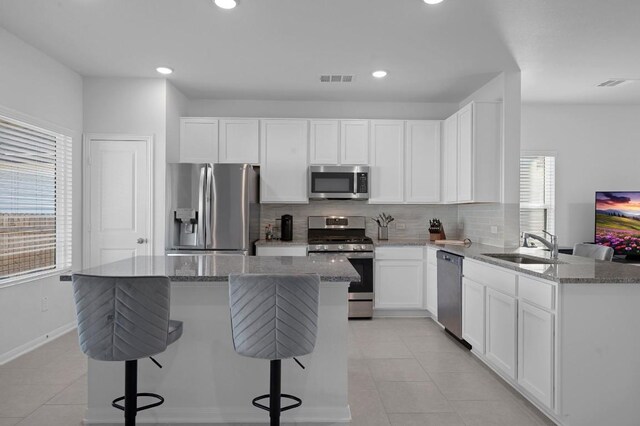 305 Ravens Crest Dr, Hutto, TX 78634 - kitchen with stainless steel appliances, light tile patterned floors, decorative backsplash, light stone countertops, and a sink