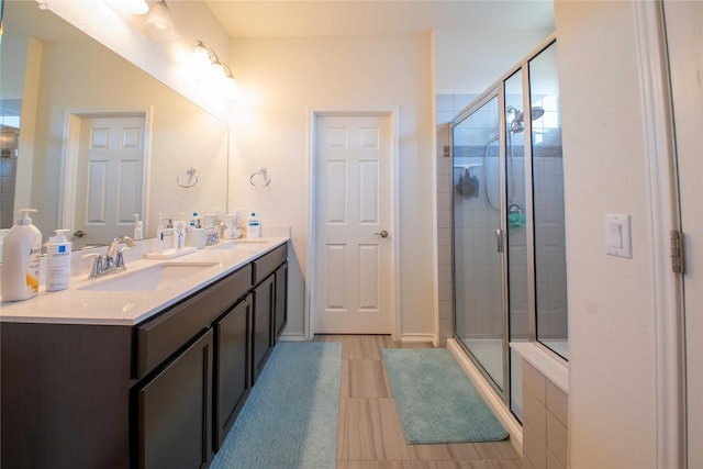 bathroom featuring a shower with door and vanity