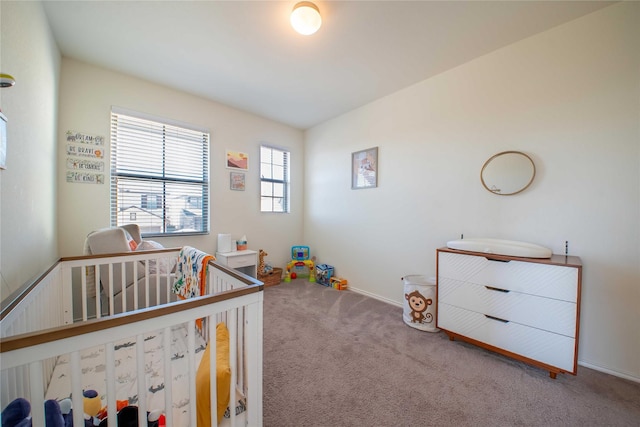 bedroom with a nursery area and carpet flooring