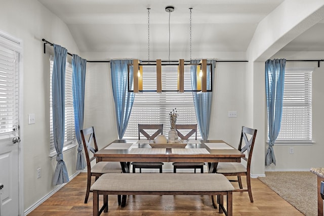 dining room featuring lofted ceiling and light wood-type flooring