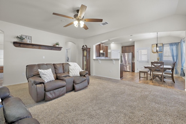 living room with ceiling fan, light colored carpet, and lofted ceiling