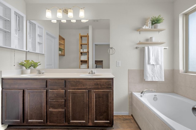 bathroom featuring vanity, hardwood / wood-style floors, and tiled tub