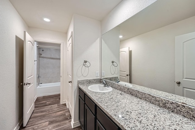 bathroom with tiled shower / bath, vanity, and hardwood / wood-style floors