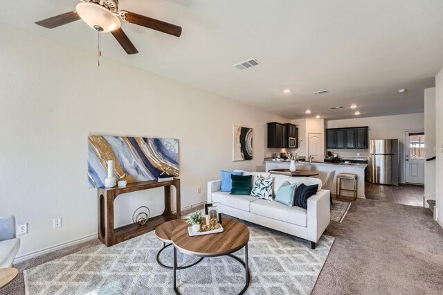 carpeted living room featuring ceiling fan