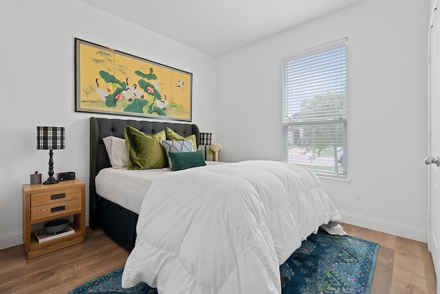 bedroom with hardwood / wood-style flooring and multiple windows