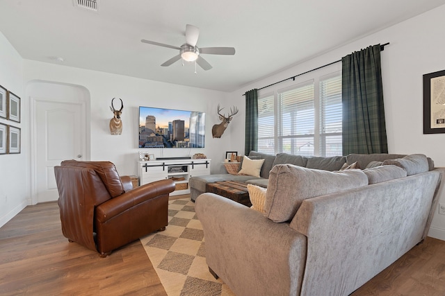 living room with wood-type flooring and ceiling fan