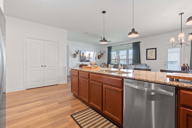 kitchen featuring decorative light fixtures, dishwasher, sink, light stone countertops, and light hardwood / wood-style flooring