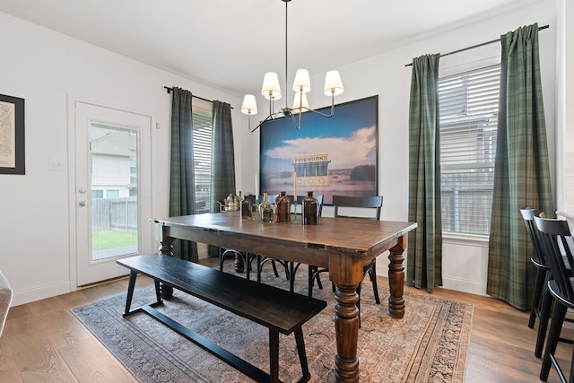 dining area featuring an inviting chandelier, a healthy amount of sunlight, and light hardwood / wood-style floors