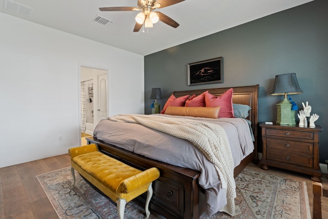 bedroom featuring ensuite bath, ceiling fan, and hardwood / wood-style flooring