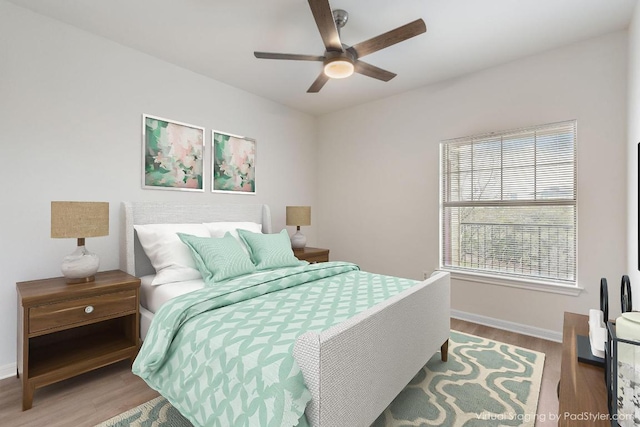 bedroom featuring ceiling fan, baseboards, and wood finished floors