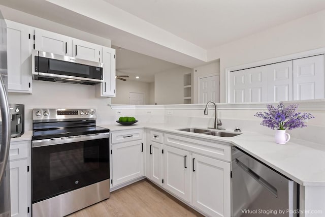 kitchen featuring light countertops, appliances with stainless steel finishes, a sink, and white cabinets