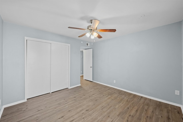 unfurnished bedroom featuring light wood-type flooring, ceiling fan, and a closet