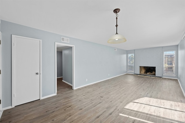 unfurnished living room with hardwood / wood-style flooring and a fireplace