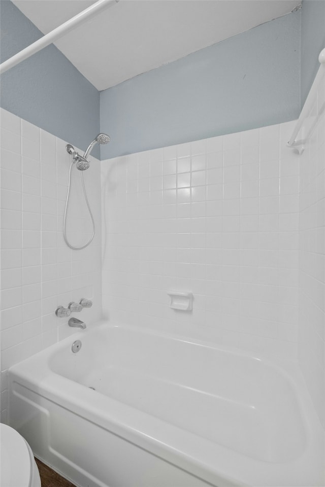 bathroom featuring tiled shower / bath and toilet