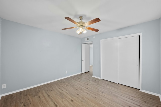 unfurnished bedroom featuring light hardwood / wood-style floors, ceiling fan, and a closet