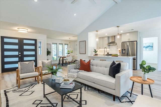 living room featuring recessed lighting, french doors, light wood-style floors, and high vaulted ceiling