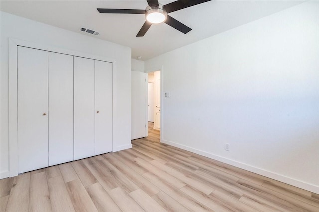 unfurnished bedroom featuring light hardwood / wood-style flooring, ceiling fan, and a closet