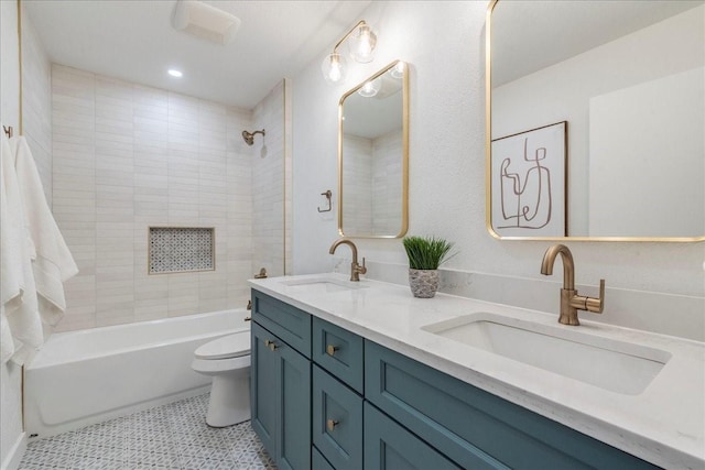 bathroom with double vanity, tub / shower combination, toilet, and a sink